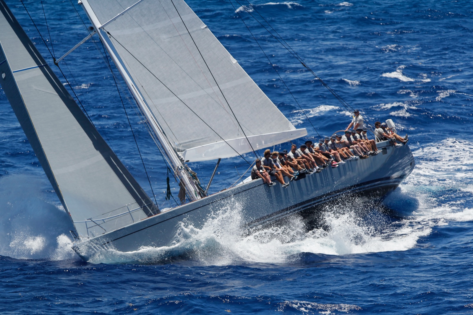 A maxi racing yacht at speed with the crew on the rail